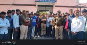 थाने में स्कूली बच्चों का पुलिस कर्मियों के साथ संवाद करते हुए फोटो।
